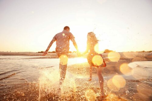 Happy,Couple,Running,On,The,Beach