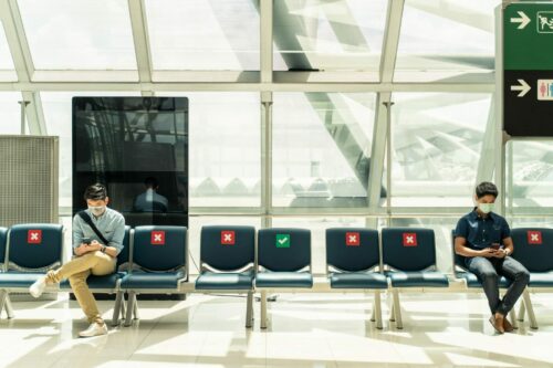 Social,Distancing,,Two,Men,Wearing,Face,Mask,Sitting,Keeping,Distance
